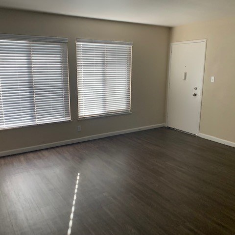 A room with wooden flooring and a white door.